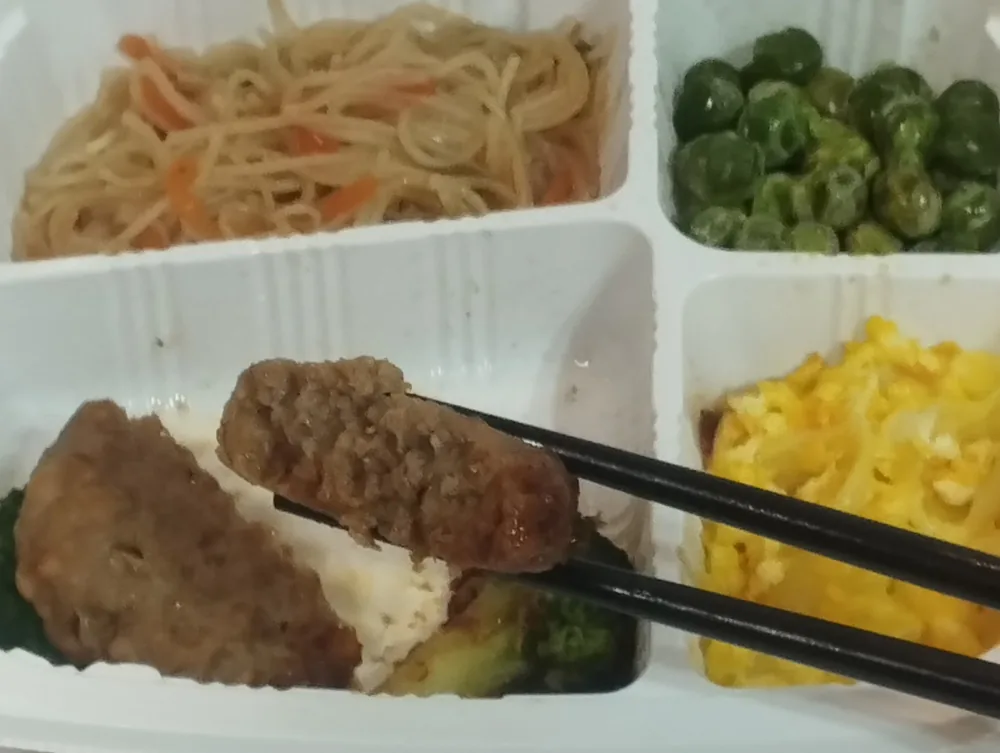 Dr.つるかめキッチンのハンバーグを箸で持ち上げたところ。デミグラスソースが絡んでいる